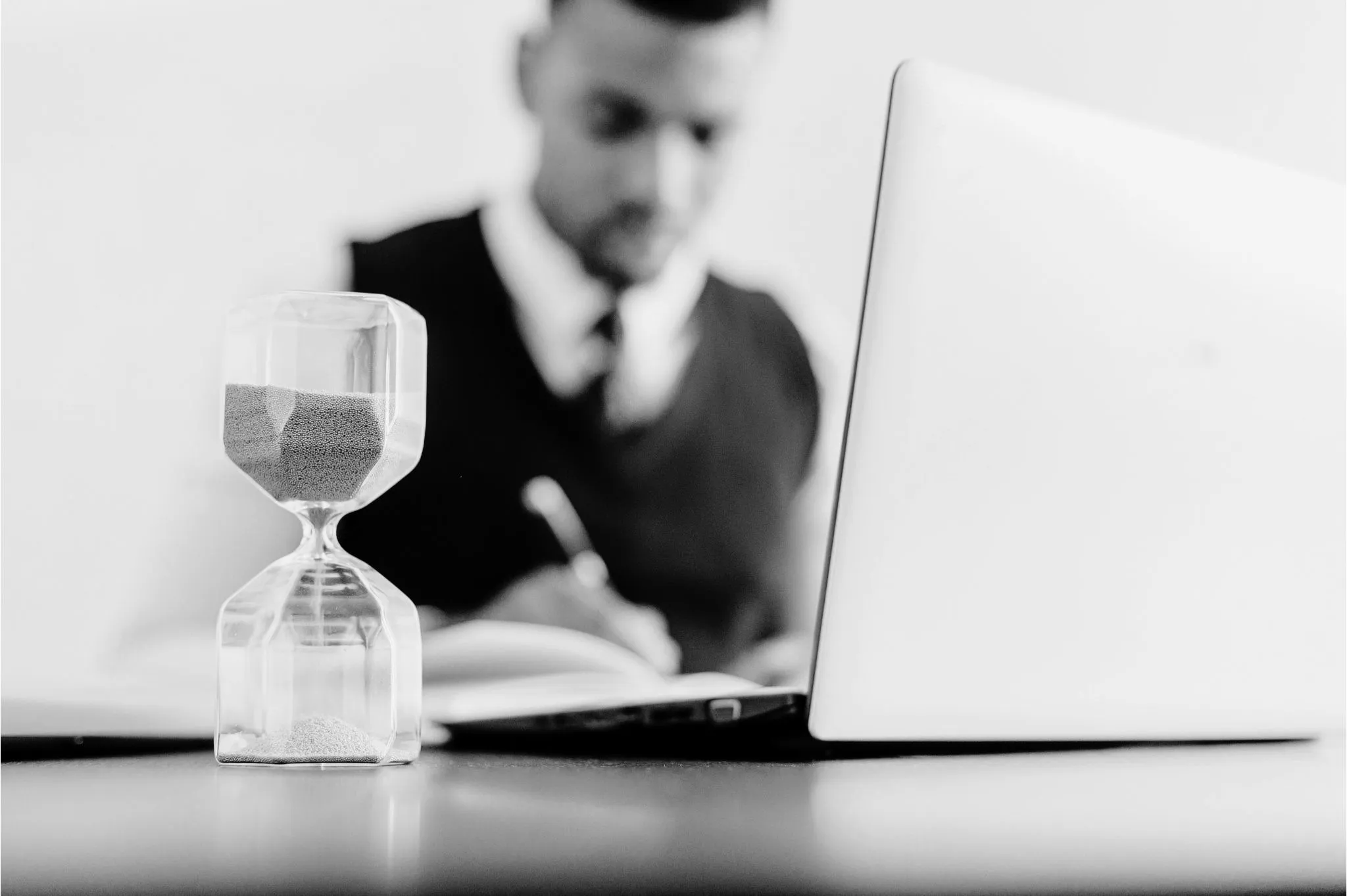 Hombre trabajando con reloj de arena en la mesa